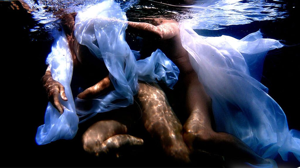Screenshot from Hermaphrodite, bodies and cloth intertwined in water